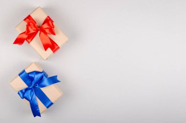 Gri arkaplan kompozisyonu üzerine hediye kutusu, kurdele ve yay ile mevcut.