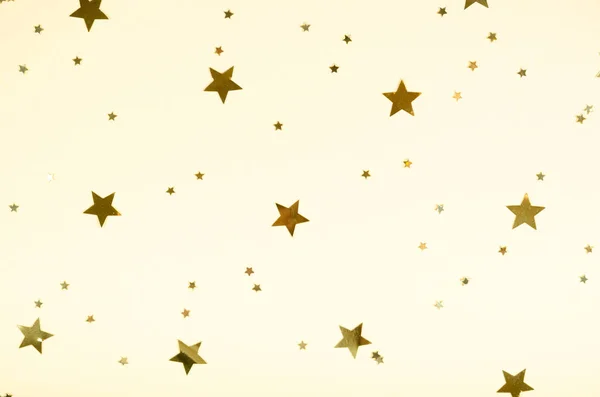 ベージュの背景、パーティーやお祝いの装飾に黄金の星の組成. — ストック写真