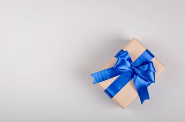 Gri arkaplan kompozisyonu üzerine hediye kutusu, kurdele ve yay ile mevcut.