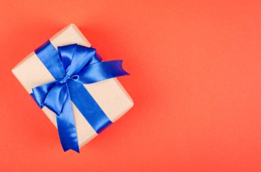 Kırmızı arkaplan kompozisyonu üzerine hediye kutusu, kurdele ve yay ile mevcut.