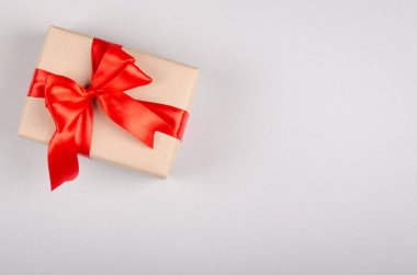 Gri arkaplan kompozisyonu üzerine hediye kutusu, kurdele ve yay ile mevcut.