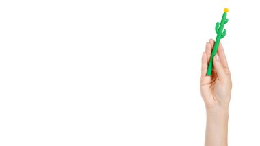 Hand with cactus shape pen, fun school tool for kids. Isolated on white background. Copy space, template.