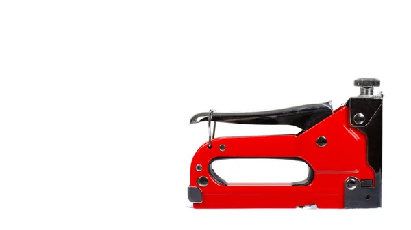 Red industrial stapler, furniture industry hardware. Isolated on white background. Copy space, template.