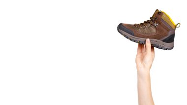Hand with brown leather kids boots. Isolated on white background. Copy space, template.