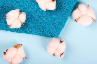 Spa fikri, pamuk ve havlu karışımı mavi arka planda. Düz yatıyordu.