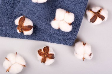 Spa fikri, gri arka planda pamuk ve havlu kompozisyonu. Düz yatıyordu.