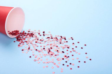 Yıldız şeklindeki konfeti fincandan arka plana saçılmış. Düz yatıyordu.