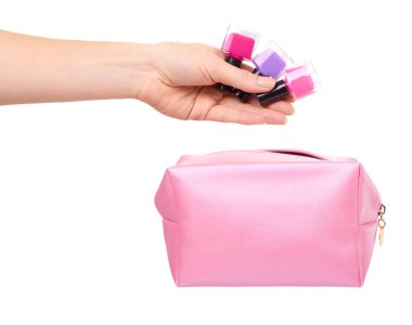 Pembe makyaj çantası ve ojeli bir el. Cazibeli kozmetik aksesuar. Beyaz arkaplanda izole.