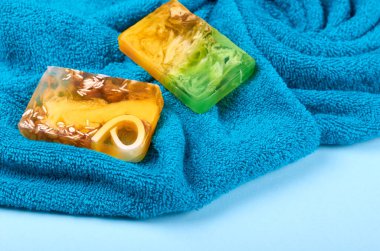 Kaplıca fikri, mavi arka planda havlu ve sabun kompozisyonu. Düz yatıyordu.