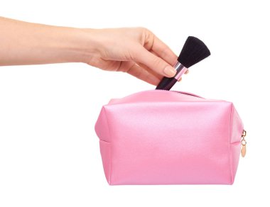 Pembe makyaj çantası ve fırçalı el. Cazibeli kozmetik aksesuar. Beyaz arkaplanda izole.