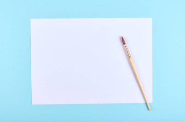 Mavi arka planda boya fırçası. Düz, yukarıdan görüntü. Uzayı kopyala, şablon.