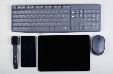 Farklı cep telefonları, cep telefonu, tablet ve gri arka planda akıllı saatler. Düz konum, genel görünüm resmi.