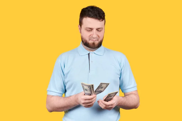Чоловік Рахує Паперові Гроші Долари Ізольовані Помаранчевому Фоні — стокове фото