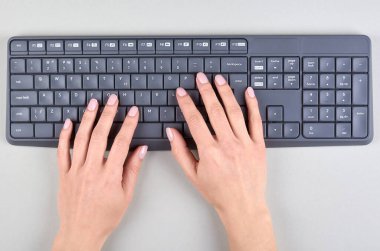 Gri arkaplanda klavye olan eller. Düz konum, genel görünüm resmi.
