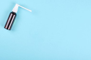 Mavi arka planda boğaz spreyi şişesi. Düz, yukarıdan görüntü. Uzayı kopyala, şablon.