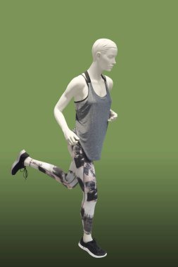 Koşan kadın manken yeşil arka planda izole edilmiş. Marka isimleri veya telif hakkı nesneleri yok.
