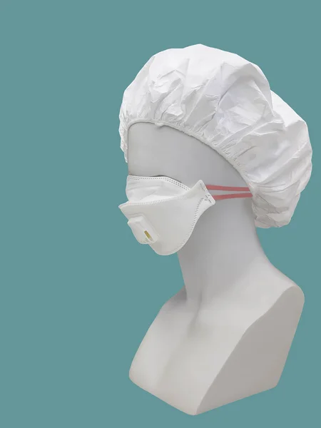 Dust mask with valve on a mannequin, isolated on green background.