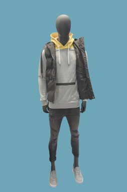 Kolsuz ceket, gömlek ve kot pantolon giymiş uzun boylu bir erkek manken. Marka isimleri veya telif hakkı nesneleri yok.