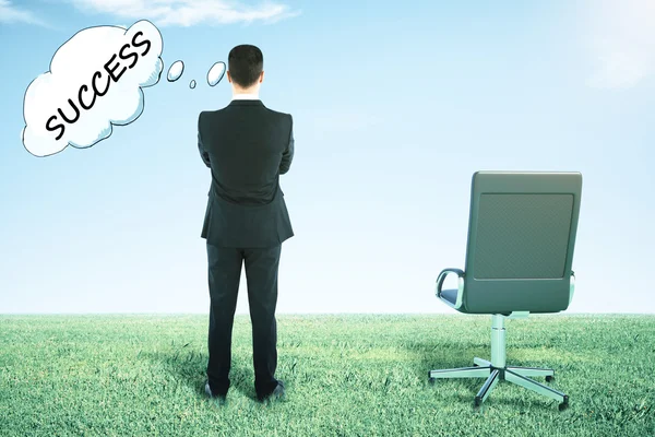 Widok z tyłu krzesła obrotowego i biznesmen na trawie patrząc w odległości i myślenia o sukcesie — Zdjęcie stockowe