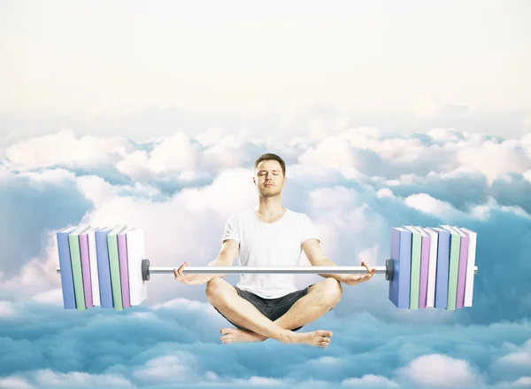 Mediteren jonge man met abstracte halter met boeken in plaats van platen op bewolkte hemel achtergrond. Education concept — Stockfoto