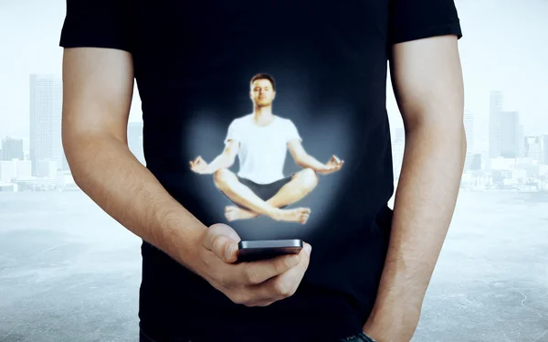 Close-up van casual man het houden van mobiele telefoon met abstracte mediteren persoon hologram. Vredes concept — Stockfoto