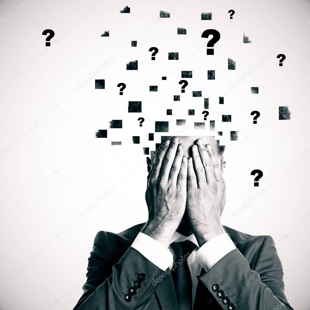 Businessman with broken into pieces head and abstract question marks on light background. Confusion concept