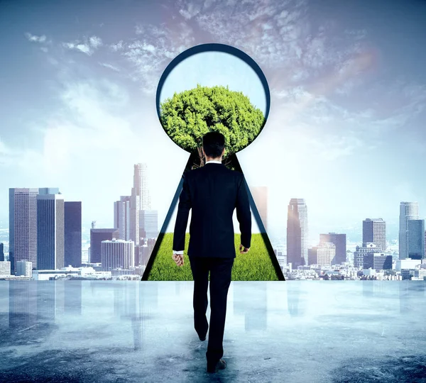 Empresario caminando a ojo de cerradura abstracto con vista al árbol en el fondo del cielo. Concepto de acceso —  Fotos de Stock