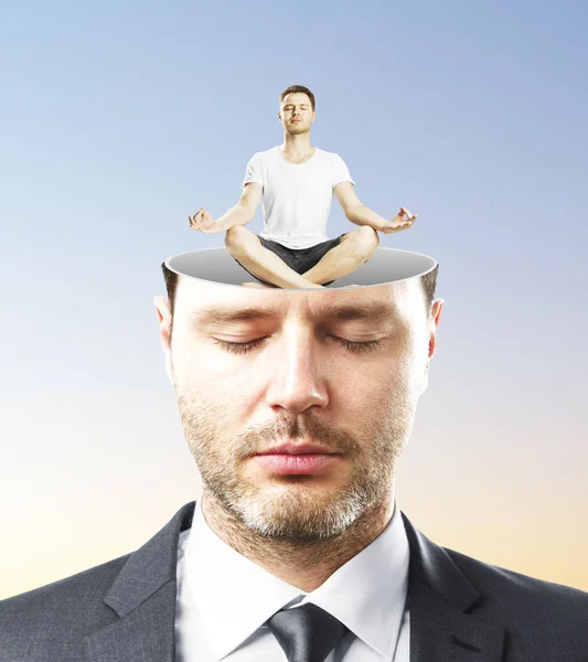 Retrato de hombre de negocios caucásico guapo con los ojos cerrados y abstracto hombre meditando miniatura dentro de la cabeza sobre fondo azul. Concepto de relajación —  Fotos de Stock