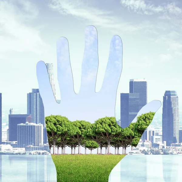 Imagen abstracta de la mano con paisaje verde sobre el fondo de la ciudad. Concepto de naturaleza —  Fotos de Stock