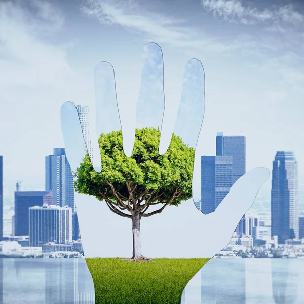 Imagen abstracta de la mano con paisaje verde sobre el fondo de la ciudad. Concepto ecológico — Foto de Stock