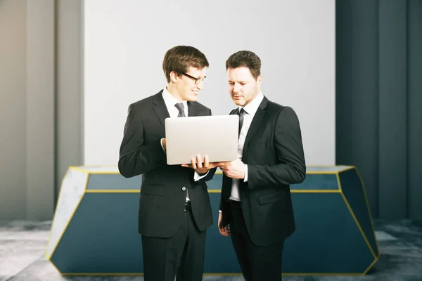 Dos hombres de negocios usando el ordenador portátil juntos — Foto de Stock