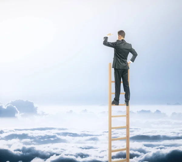 Uomo d'affari sulla scala guardando in lontananza sullo sfondo del cielo. Concetto di ricerca — Foto Stock