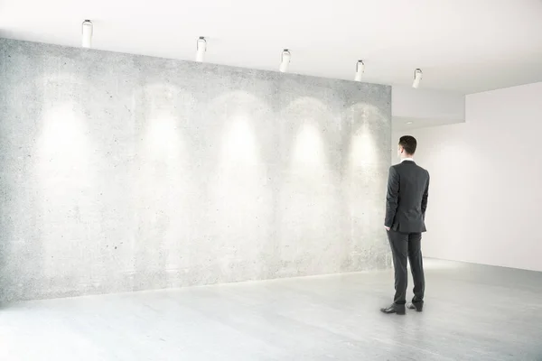Empresário no quarto com lado vazio da parede — Fotografia de Stock