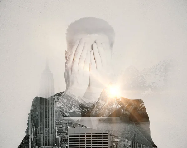 Man die betrekking hebben op gezicht met handen op abstracte achtergrond van stad en natuur met zonlicht. Angst concept — Stockfoto