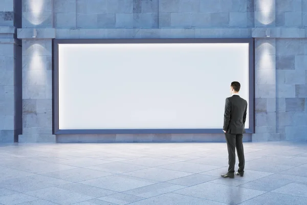 Člověk při pohledu na prázdné billboard — Stock fotografie