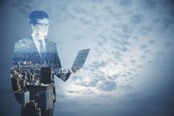 Uomo d'affari che utilizza il computer portatile su sfondo astratto città e cielo con spazio di copia. Concetto di comunicazione — Foto Stock