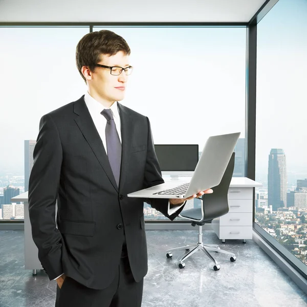 Gutaussehender Geschäftsmann mit Laptop im Innenraum mit Blick auf die Stadt und Arbeitsplatz. 3D-Darstellung. Technologiekonzept — Stockfoto