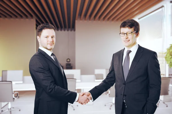 Beaux hommes d'affaires serrant la main dans un bureau moderne. Concept de partenariat. Rendu 3D — Photo