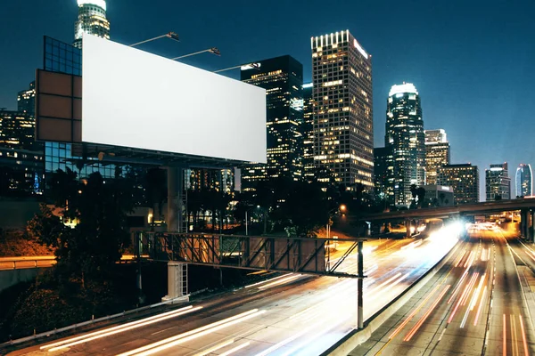 Vista lateral de la cartelera blanca en blanco en la ciudad nocturna. Concepto publicitario. Maquillaje, renderizado 3D — Foto de Stock