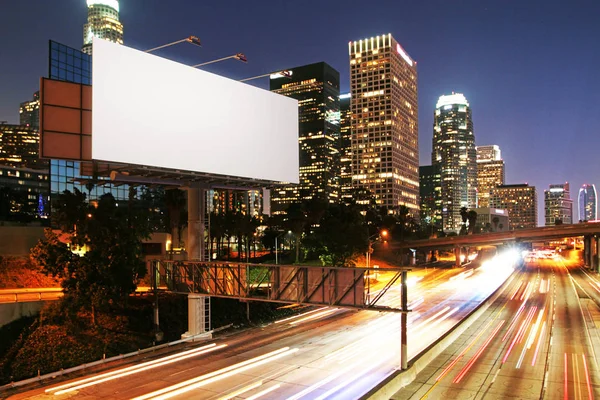 Vista lateral de la cartelera blanca en blanco en la ciudad nocturna. Concepto publicitario. Maquillaje, renderizado 3D — Foto de Stock