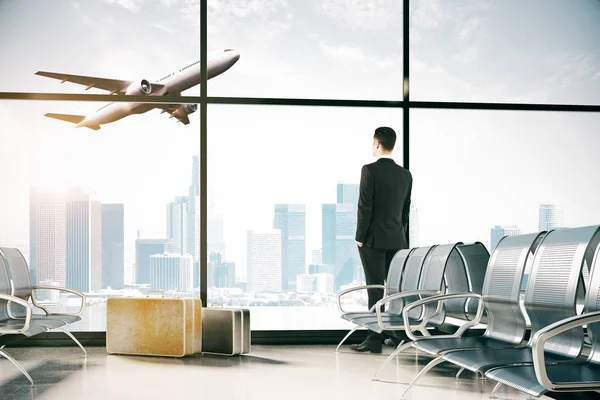 Geschäftsmann schaut aus dem Fenster im Flughafeninnenraum mit Stahlsitzen, Gepäck und Panoramablick auf den Himmel, wenn er mit dem Flugzeug fliegt. 3D-Darstellung — Stockfoto