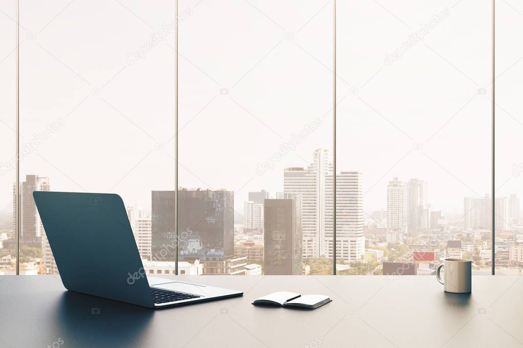 Front view of office desktop with open laptop, notepad and coffee cup on panoramic city view background. 3D Rendering