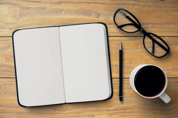 Desktop with notepad, mug and glasses — Stock Photo, Image