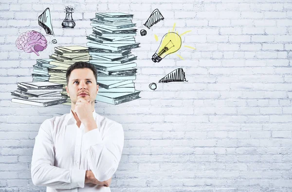 Hombre de negocios reflexivo sobre fondo de ladrillo blanco con montón de papeleo dibujado. Concepto de carga — Foto de Stock