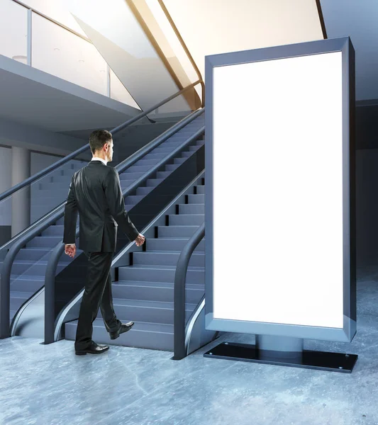 Boş billboard yanında yürüyen merdiven üzerinde iş adamı. Perakende kavramı. Alay etmek yukarıya, 3d render — Stok fotoğraf