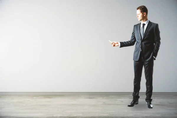 Businessman drawing on light wall — Stock Photo, Image