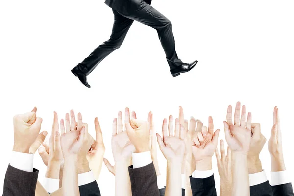 Múltiplas mãos tentando alcançar empresário em execução no fundo branco. Conceito de liderança — Fotografia de Stock