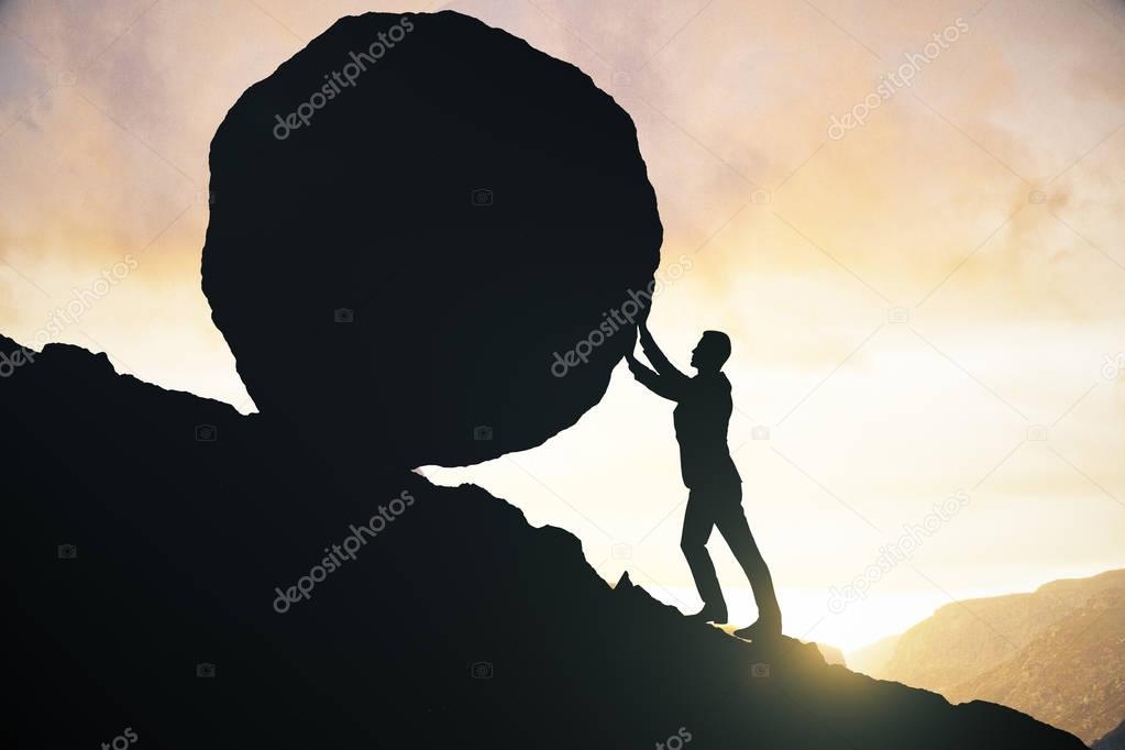 Side view of male silhouette pushing huge rock uphill. Beautiful sky background. Struggle concept