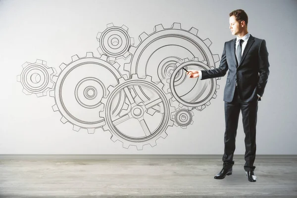 Businessman drawing cogwheel sketch in interior. Teamwork concept. 3D Rendering — Stock Photo, Image