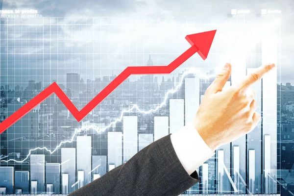 Röd diagram pil och pekar businessman's hand på staden med business diagrammets bakgrund. Finance koncept — Stockfoto